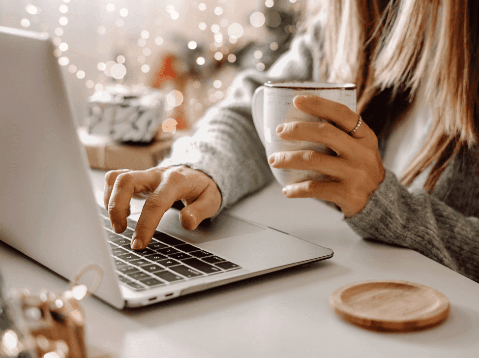 Manažerka pracující na počítači s šálkem teplého čaje