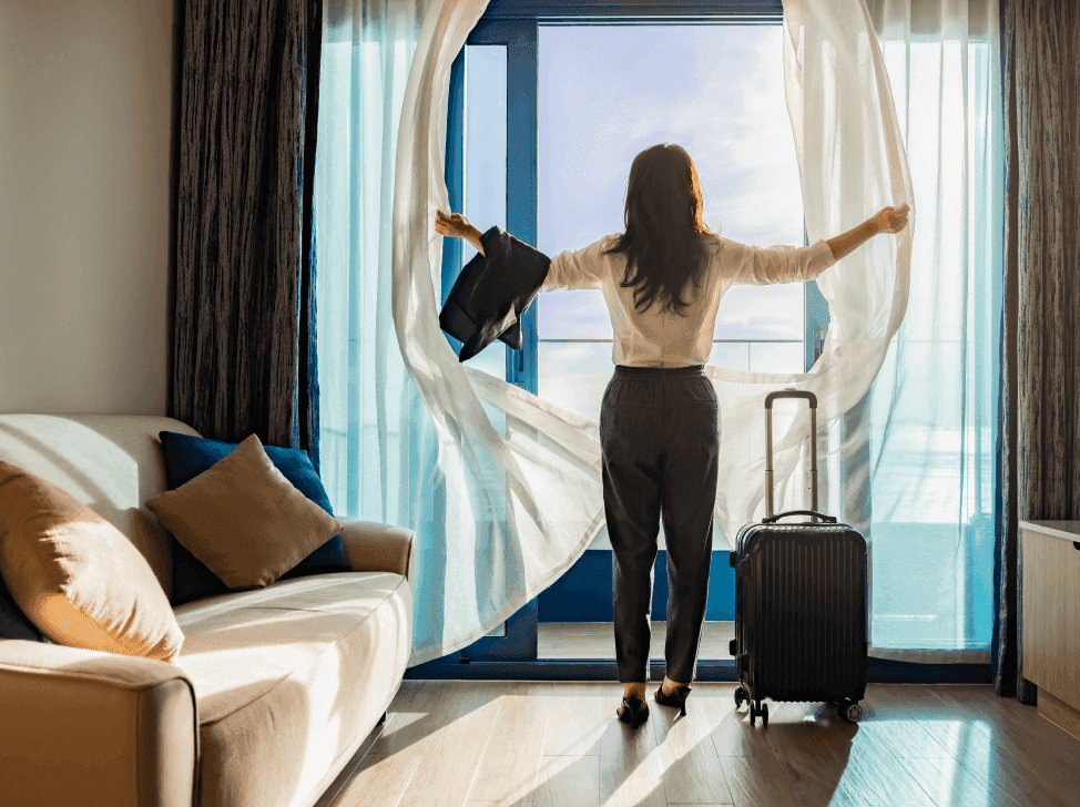Žena s kufrem na hotelovém pokoji