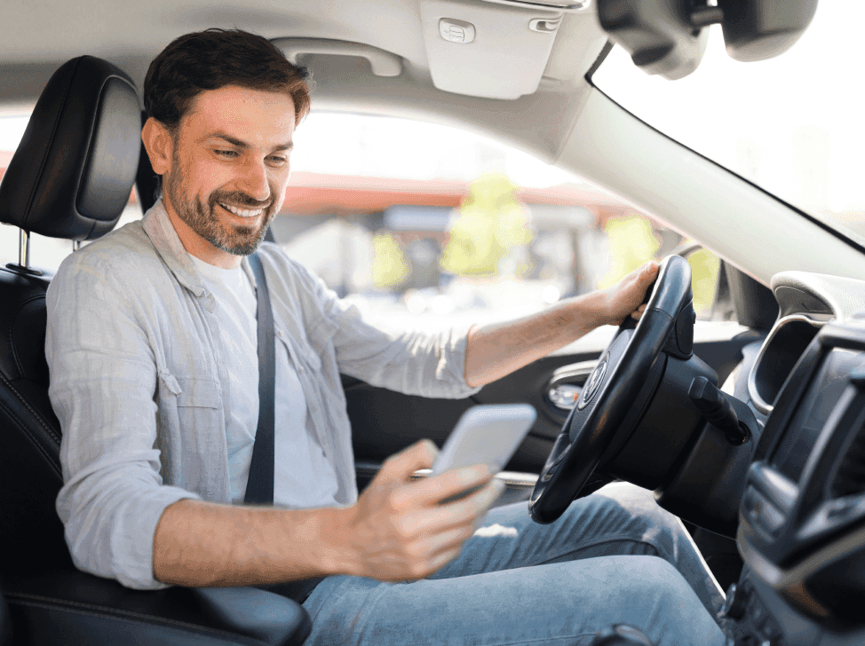 Muž kontroluje cestovní příkaz v mobilu v autě