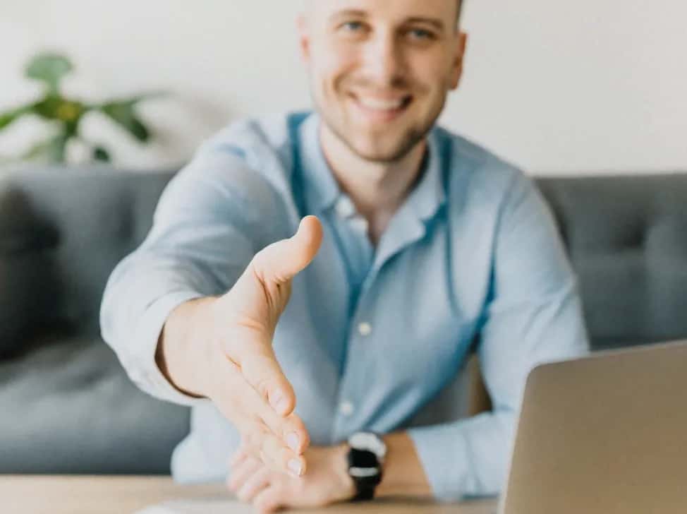 Muž s notebookem podávající ruku