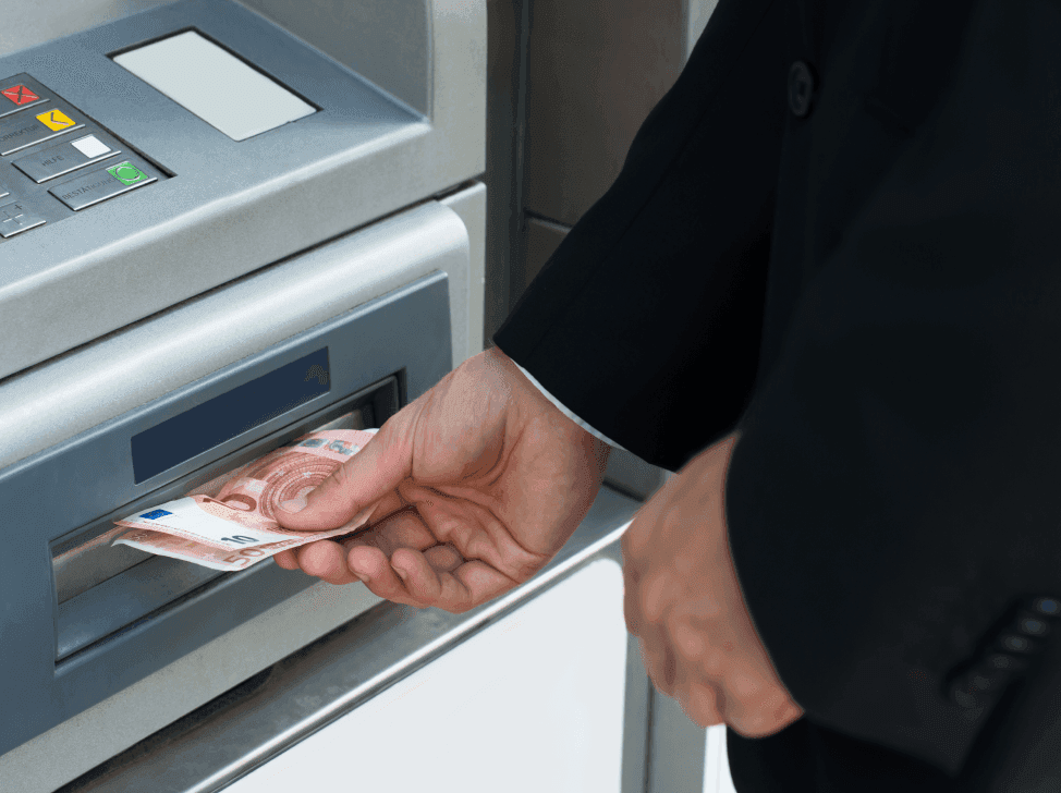 Muž vybírající peníze z bankomatu