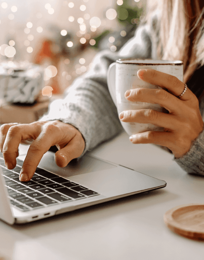 Manažerka pracující na počítači s šálkem teplého čaje