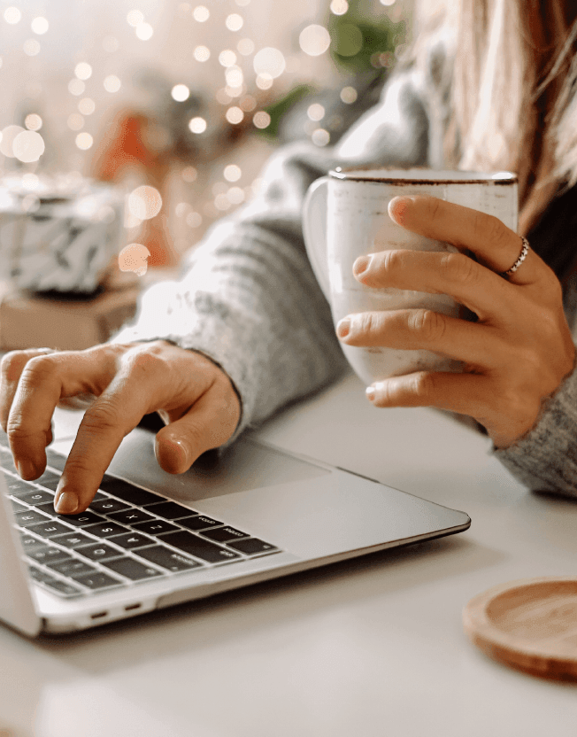 Manažerka pracující na počítači s šálkem teplého čaje