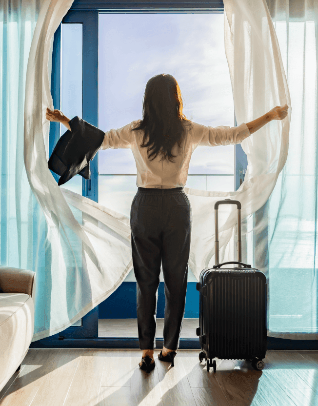 Žena s kufrem na hotelovém pokoji