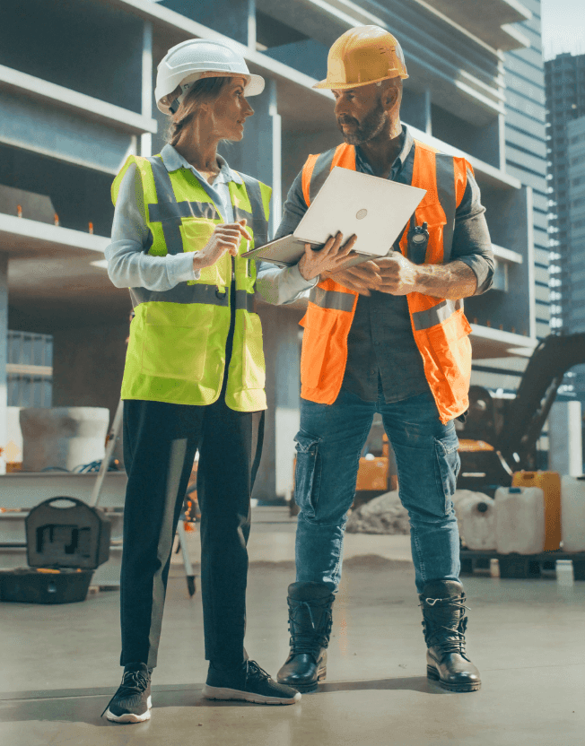 Stavbyvedoucí ukazuje přehled výdajů na stavbu na počítači