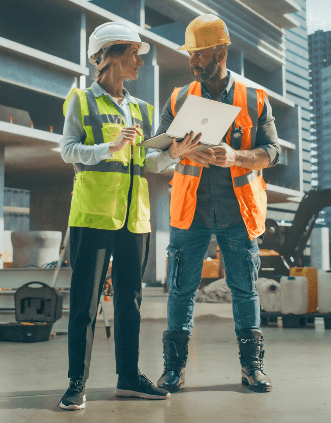 Stavbyvedoucí ukazuje přehled výdajů na stavbu na počítači