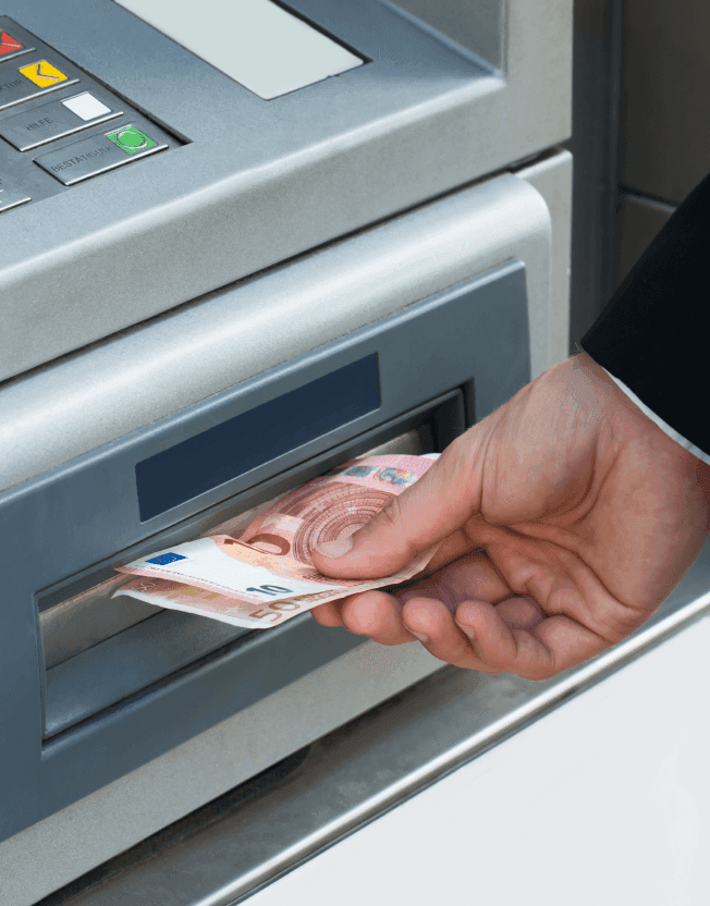 Muž vybírající peníze z bankomatu