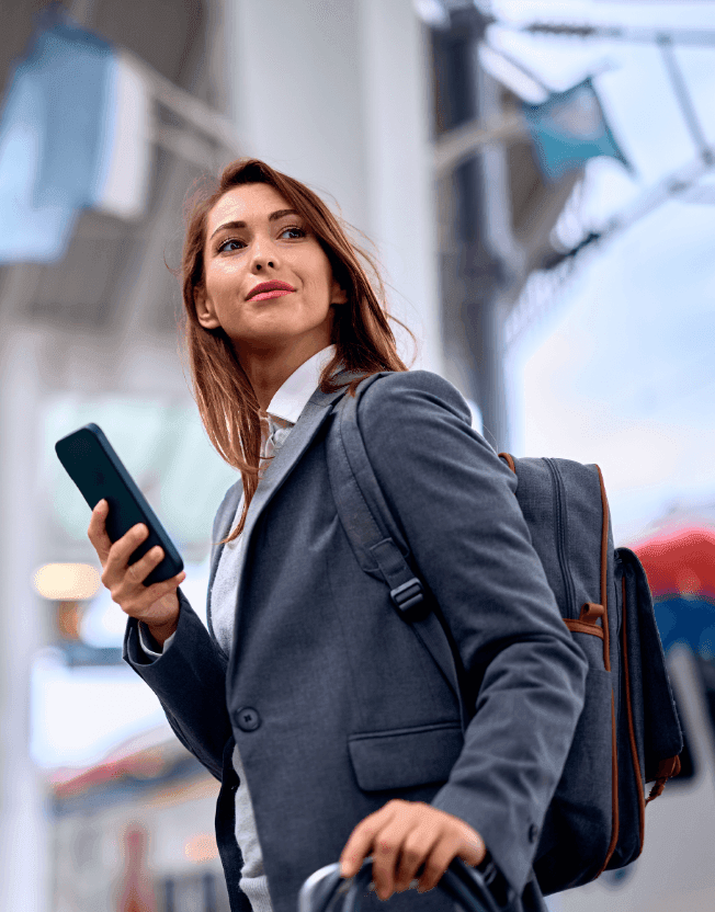 Byznys žena se zavazadlem a mobilem v ruce na letišti