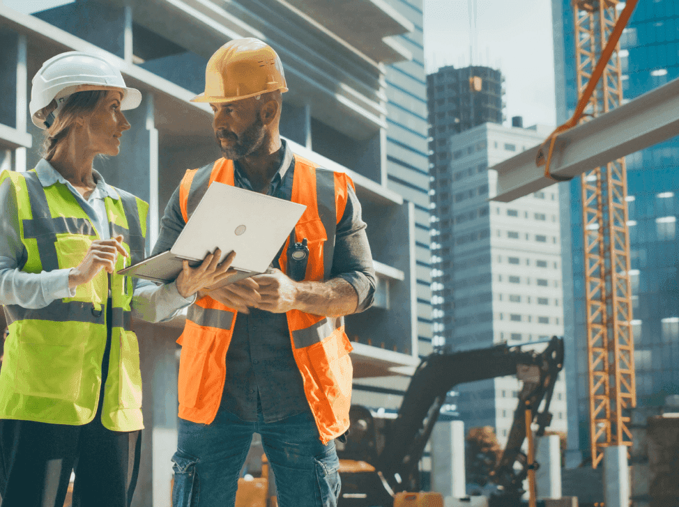 Stavbyvedoucí ukazuje přehled výdajů na stavbu na počítači