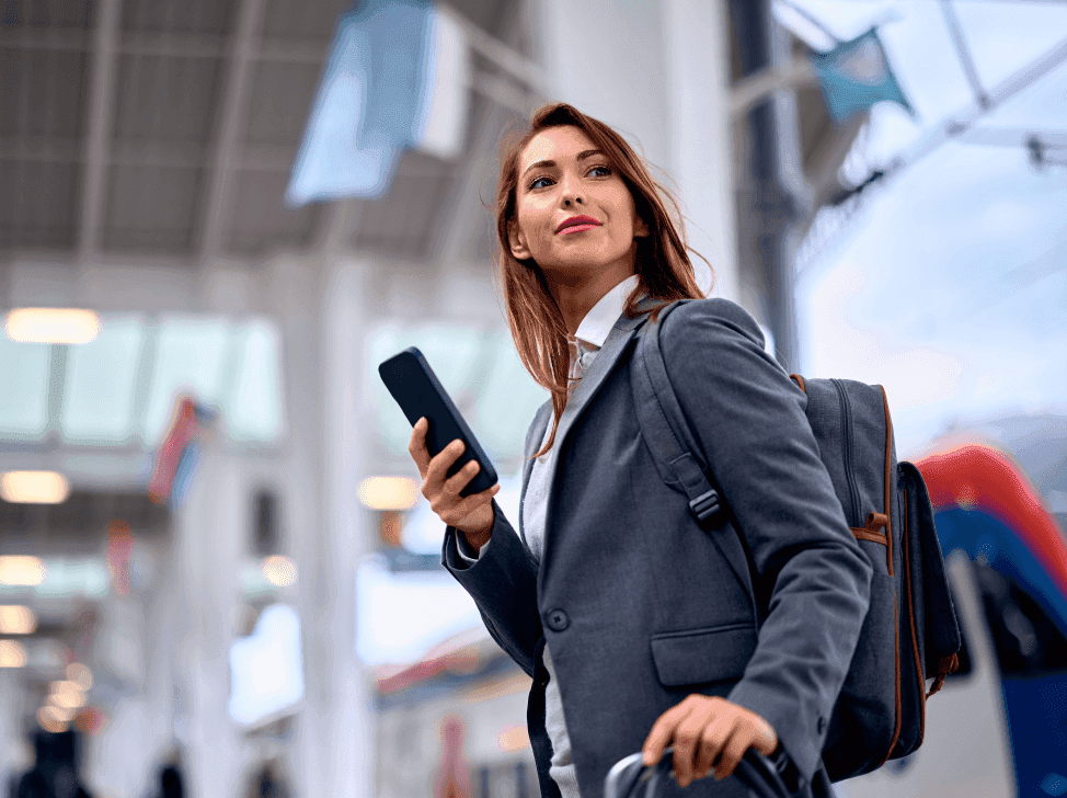 Byznys žena se zavazadlem a mobilem v ruce na letišti